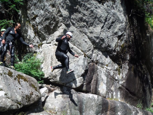 Jeune homme sautant dans une vasque du canyon du Tapoul, canyoning en eau vive dans les Cévennes.