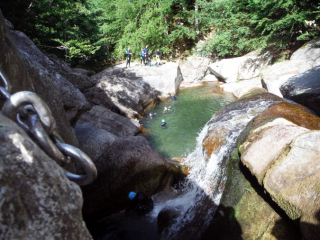 Groupe de participants se reposant dans une vasque du canyon du Tapoul, en sortie canyoning en Cévennes.