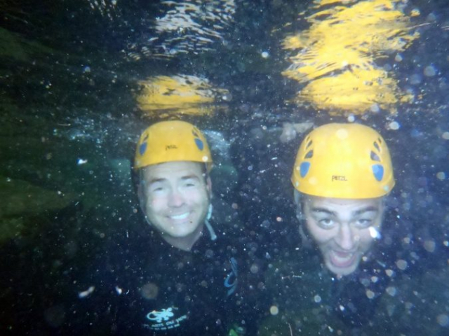 Deux participants souriants sous l’eau dans le canyon du Tapoul, en pleine nature dans les Cévennes.